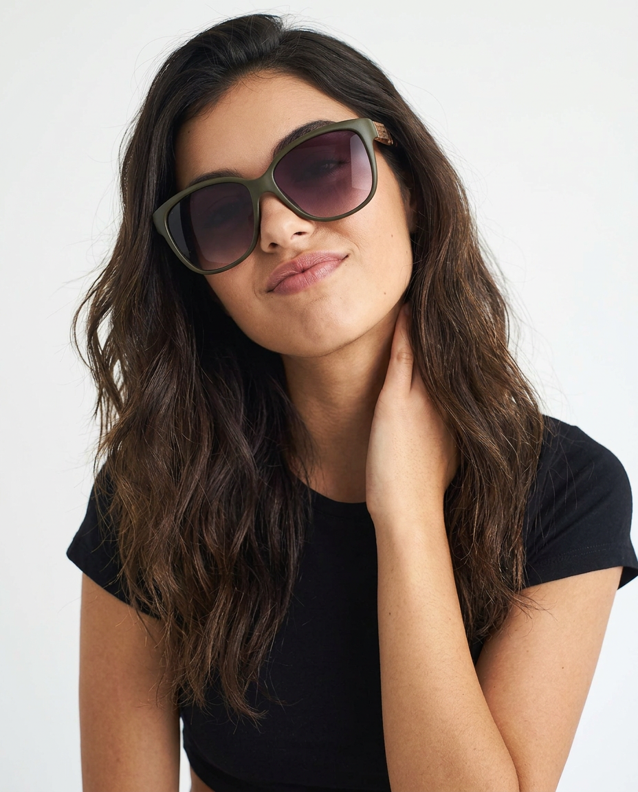 SH6660 Lady - Beachtime Sunglasses Woman wearing oversized olive-green sunglasses and a black t-shirt, tilting her head slightly and touching her neck with one hand.