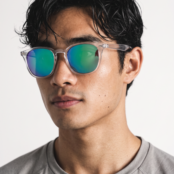 Young man with black hair wearing mirrored blue-green sunglasses and a gray T-shirt.