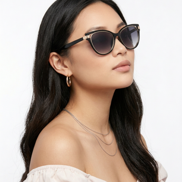 Woman with long dark hair wearing oversized black sunglasses, gold hoop earrings, and layered silver necklaces against a light background?