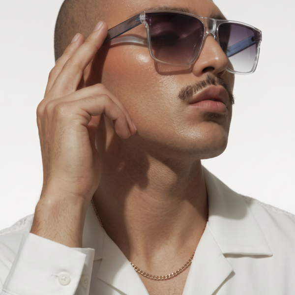 Close-up portrait of a man wearing translucent sunglasses and a white collared shirt.